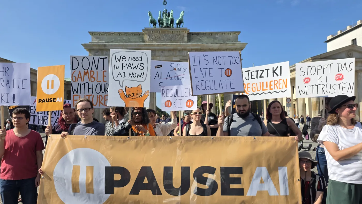 PauseAI-Demonstration mit Banner und Schildern vor dem Brandenburger Tor in Berlin